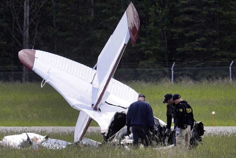 FILE- In this July 8, 2013 file photo, National Transportation and Safety Board go-team members examine the remains of an aircraft wreck in Soldotna, Alaska. The National Transportation Safety Board plans to release on Wednesday, Sept. 17, 2014 hundreds of pages from its investigation into an air taxi crash that killed 10 people.  (AP Photo/Peninsula Clarion, Rashah McChesney, File)