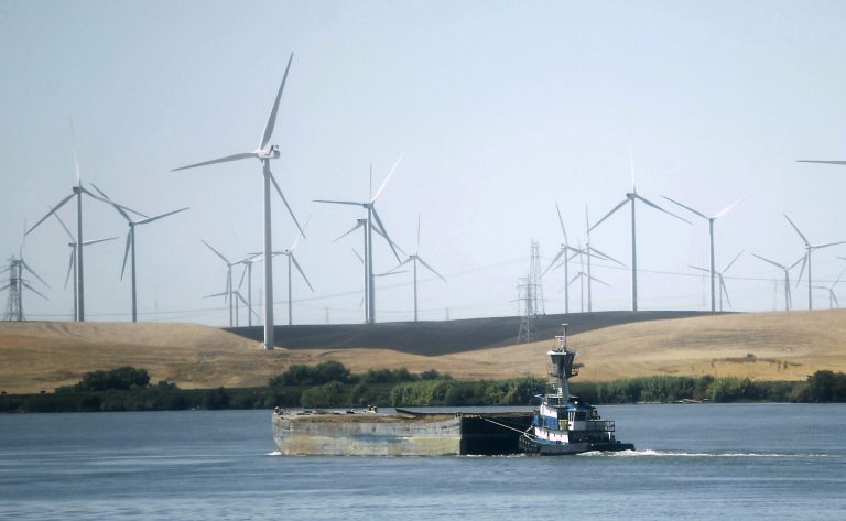 A tugboat pushes a barge down the Sacramento River past wind turbines near Rio Vista, Calif., on Sept. 23, 2013.Â Only California's wind turbines have returned to normal production since the spring, with states in the Northwest still suffering from below-average production, the EIA says. Â (AP Photo/Rich Pedroncelli)