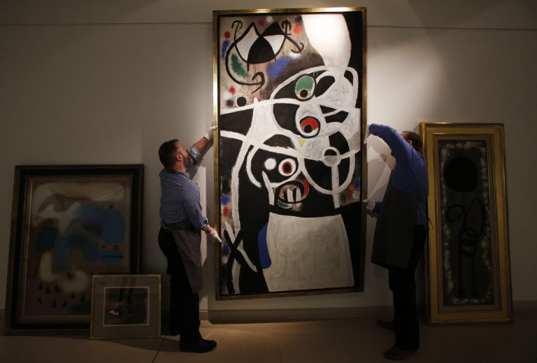 FILE - In this Thursday, Dec. 19, 2013 file photo, auction house workers adjust Joan Miro's 1968 oil painting 
