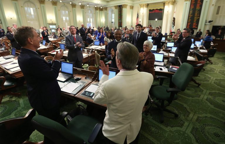Assemblyman Tom Ammiano, D-San Francisco, foreground, receives a standing ovation from lawmakers after he presented his last bill before the Assembly at the Capitol in Sacramento, Calif., Friday, Aug. 29, 2014.   By a 45-17 vote the Assembly approved Ammianno's bill, AB885, which will allow juries in criminal cases to consider whether prosecutors intentionally withheld evidence when deliberating a verdict.  This was Ammiano's last piece of legislation as he is leaving office due to term limits.(AP Photo/Rich Pedroncelli)