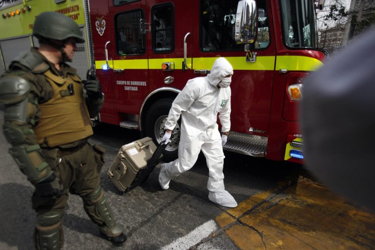 FILE - In this Sept. 8, 2014 file photo, a police forensic expert arrives to the blast site at a subway station in Santiago, Chile. Interior and Security Minister Rodrigo Penailillo confirmed the arrests of two men and a women Thursday, Sept. 18, 2014, in connection with the Sept. 8 bomb attack that injured 14 people. (AP Photo/Luis Hidalgo, File)