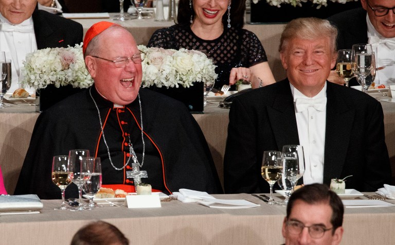 Election Day exit polls show Donald Trump prevailing among Catholic voters by 52 to 45 percent. Above, Trump, right, laughs at a joke with Cardinal Timothy Dolan during the Alfred E. Smith Memorial Foundation dinner in October. (AP Photo/ Evan Vucci)
