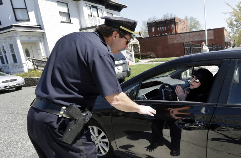 A police officer speaks with a woman in Muslim dress as she pulls into an entrance to the Graham, Putnam, at Mahoney Funeral Parlors in Worcester, Mass., Monday, May 6, 2013 where the body of killed Boston Marathon bombing suspect Tamerlan Tsarnaev is being prepared for burial. Funeral director Peter Stefan has pleaded for government officials to use their influence to convince a cemetery to bury Tsarnaev, but so far no state or federal authorities have stepped forward. (AP Photo/Elise Amendola)