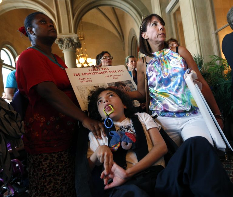 Oliver Miller, 14, center, with his mother Missy Miller, right, and nurse Sandra Sanon during a rally in support of medical marijuana at the Capitol on Wednesday, June 18, 2014, in Albany, N.Y. Dozens of advocates for legalizing medical marijuana are blaming Gov. Andrew Cuomo for stalling the so-called 
