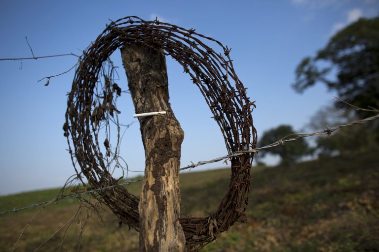 In this Dec. 7, 2016 photo, a lone cigarette rests on a fence post as Honduran migrant and Mexican workers sort and pack used plastic bottles to be compacted and sold to a recycling plant, at a rural dump on the outskirts of Tenosique, Tabasco state, Mexico. More than 8,000 immigrants have asked the Mexican government to grant them asylum this year. (AP Photo/Rebecca Blackwell)
