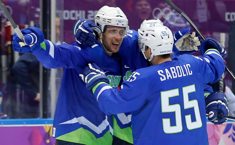 Slovenia forward Anze Kopitar, left, forward Robert Sabolic (55) and Slovenia forward Rok Ticar celebrate after a third period goal against Slovakia during a men's ice hockey game at the 2014 Winter Olympics, Saturday, Feb. 15, 2014, in Sochi, Russia. (AP Photo/Julio Cortez)