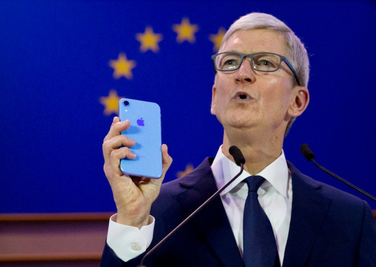 Apple CEO Tim Cook holds up an iPhone as he speaks during a data privacy conference at the European Parliament in Brussels, Wednesday, Oct. 24, 2018.                
