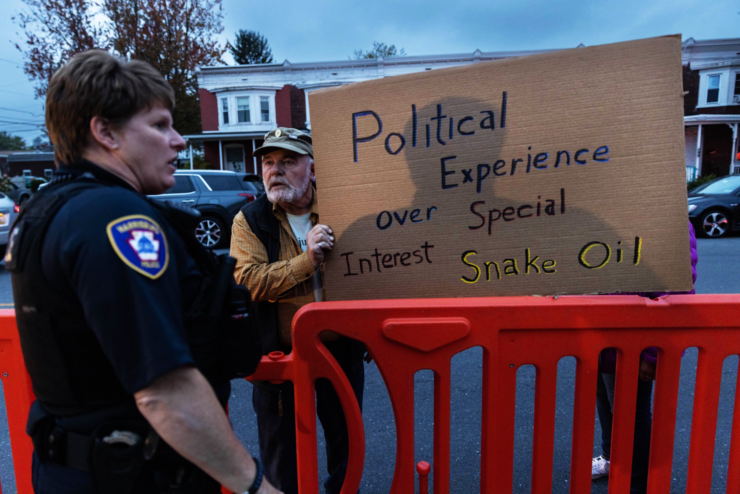 A police officer speaks with a protester outside the senatorial debate night tent between Democratic candidate John Fetterman and Republican candidate Mehmet Oz, in Harrisburg, Pennsylvania, Wednesday, Oct. 25, 2022.