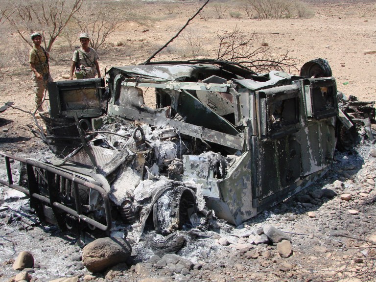 In this Thursday, May 1, 2014 photo provided by Yemen's Defense Ministry, soldiers inspect the wreckage of a vehicle destroyed during fighting with al-Qaida militants in Majala of the southern province of Abyan, Yemen. (AP Photo/Yemen's Defense Ministry)