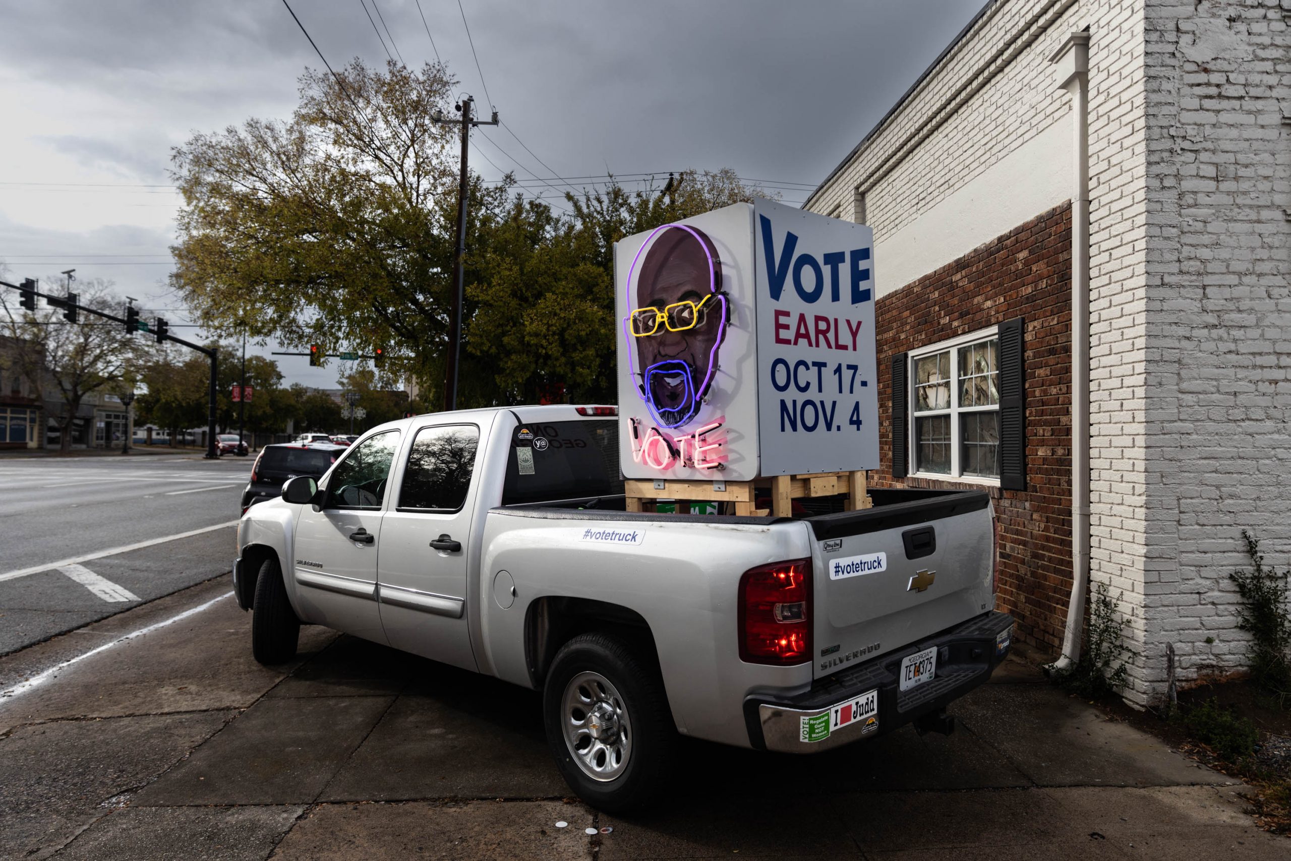 A truck with a neon sign depicting the face of Sen. Raphael Warnock outside a Democratic field office in Augusta, Georgia, Saturday, November 5, 2022 