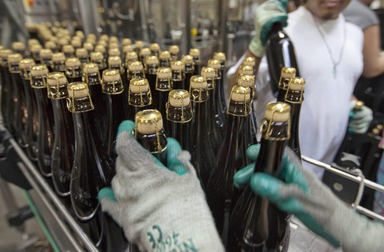   FILE - In this July 1, 2013, file photo, bottles of Brooklyn Local 2 are loaded on to a conveyor for labeling, at the Brooklyn Brewery, in the Williamsburg section of the Brooklyn borough of New York. The Commerce Department reports on orders placed with U.S. factories in July on Thursday, Sept. 5, 2013. (AP Photo/Richard Drew, File)  