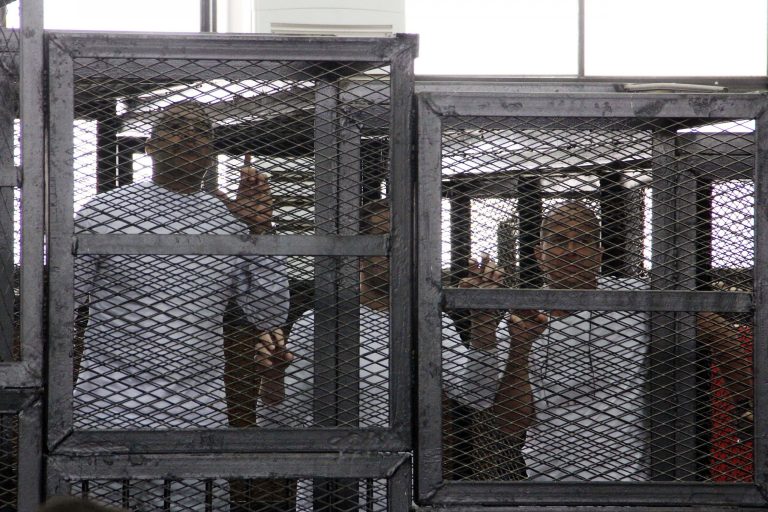 Al-Jazeera English bureau chief Mohammed Fahmy, left, producer Baher Mohamed, center and correspondent Peter Greste, right, appear in a defendant's cage in a courtroom along with several other defendants during their trial on terror charges, in Cairo, Egypt, Monday, March 31, 2014. Two Al-Jazeera journalists on trial in Egypt have directly asked with the judge to release them. Australian Peter Greste and Canadian-Egyptian Mohammed Fahmy are among three journalists and 17 others who are facing terrorism-related charges, based on accusations by authorities that they provided a platform to the outlawed Muslim Brotherhood group of ousted President Mohammed Morsi.(AP Photo/Heba Elkholy, El Shorouk) EGYPT OUT