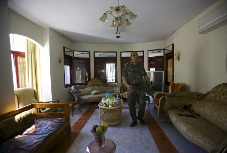 A Palestinian officer from Hamas security forces walks through a room in Palestinian President Mahmoud Abbas's house while they clear the house before they give it to Fatah representatives in Gaza City, in the northern Gaza Strip, Wednesday, May 14, 2014. Hamas on Wednesday cleared out of the private Gaza residence of Palestinian President Mahmoud Abbas, in the most concrete sign yet that the rivals are moving toward reconciliation. (AP Photo/Adel Hana)