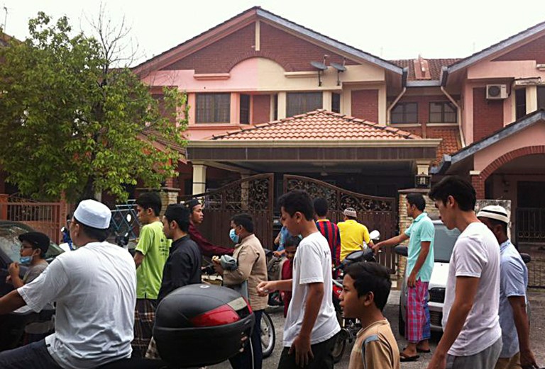 Muslim men leave a mosque after Friday prayers, just down the road of the home of Fariq Abdul Hamid, co-pilot of the missing Malaysia Airlines jetliner MH370, center, Friday, March 14, 2014 in Shah Alam, Malaysia. The pilots of the missing Malaysia Airlines passenger jet were a contented middle-aged family man passionate enough about flying to build his own simulator and a 27-year-old contemplating marriage who had just graduated to the cockpit of the Boeing 777. Details about the men have emerged from interviews with neighbors, Malaysia Airlines staff, a religious leader and from social networks and news reports in Malaysia and Australia.(AP Photo/Eileen Ng)