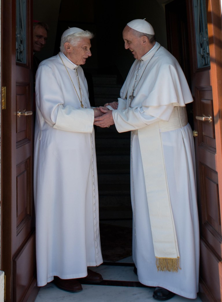 RETRANSMISSION OF OSS101 TO PROVIDE DIFFERENT CROP -- In this photo provided by the Vatican newspaper L'Osservatore Romano, Pope emeritus Benedict XVI, left, is welcomed by Pope Francis as he returns at the Vatican from the pontifical summer residence of Castel Gandolfo, 35 km South-Est from Rome, Thursday, May 2, 2013. Emeritus Pope Benedict XVI came home on Thursday to a new house and a new pope, as an unprecedented era begins of a retired pontiff living side-by-side with a reigning one inside the Vatican gardens. In background is archbishop George Gaenswein, prefect of the papal household. (AP Photo/Osservatore Romano, HO)