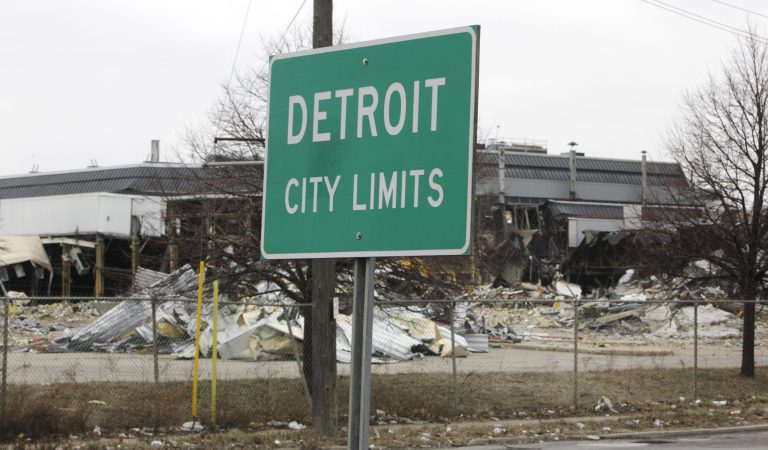 A street sign showing Detroit's city limits is shown near where a former Chrysler McGraw glass plant is being torn down along Ford Road in Detroit. (AP Photo/Paul Sancya)