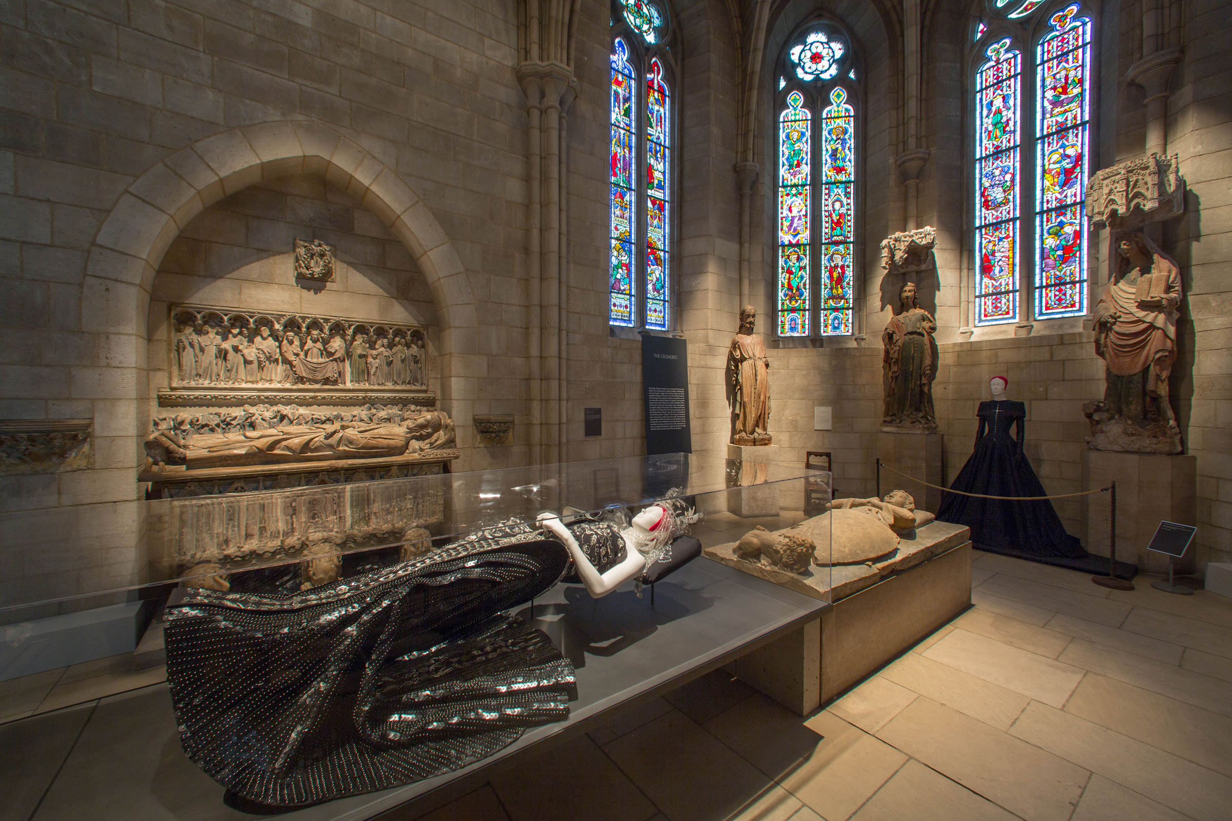 The Met's Heavenly Bodies exhibition (2018) - Inside the Gothic chapel in the Cloisters, a 2006 ensemble created by John Galliano for Dior (foreground) and an evening dress designed by Olivier Theyskens in 1999.