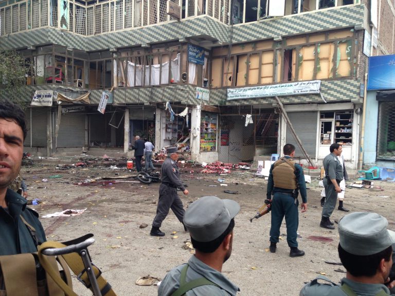 Afghan security forces inspect the site of a suicide attack near a bank branch in Jalalabad, east of Kabul, Afghanistan, Saturday, April 18, 2015. The suicide bomb attack on the bank branch has killed dozens of people, officials said. (AP Photo)