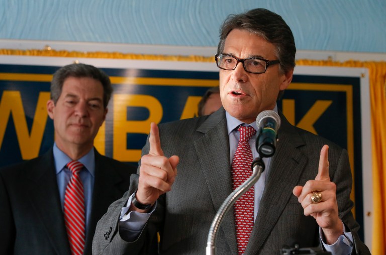 Texas Gov. Rick Perry stumps for Kansas Gov. Sam Brownback, left, during a campaign rally for Brownback on Wednesday, Sept. 24, 2014 in Wichita, Kan. Brownback is facing a tough reelection campaign against democrat Paul Davis. (AP Photo/The Wichita Eagle, Travis Heying)