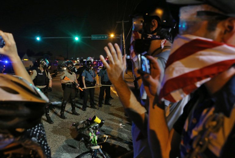 Police stand guard near protestors Monday, in Ferguson, Mo. The Aug. 9 shooting of Michael Brown by police has touched off rancorous protests in Ferguson, a St. Louis suburb where police have used riot gear and tear gas. (AP Photo/St. Louis Post-Dispatch, J.B. Forbes)