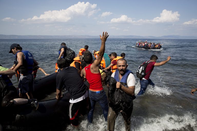 Migrants and refugees arrive on a dinghy after crossing from Turkey to Greece, as another one approaches the coast of Lesbos island, Tuesday, Sept. 8, 2015. (AP Photo/Petros Giannakouris)