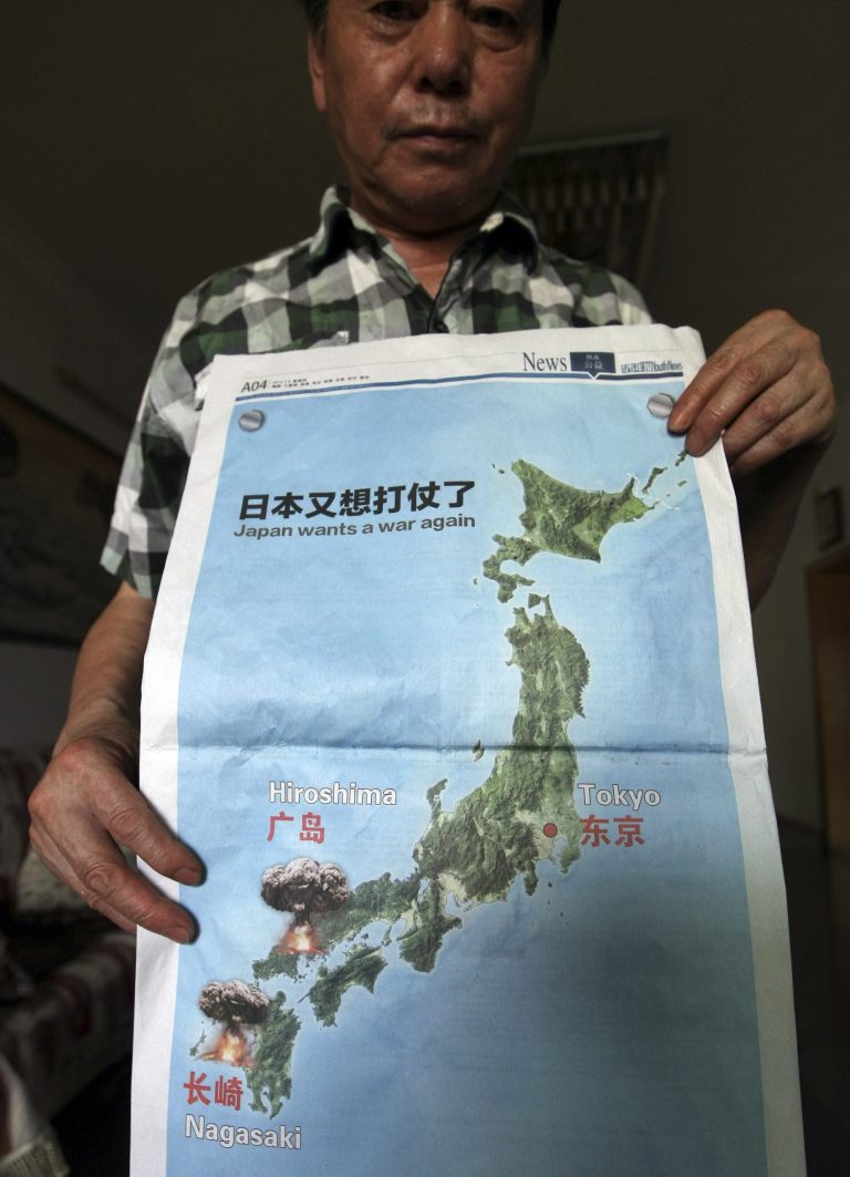 A man poses with a full page advertisement with the headline 