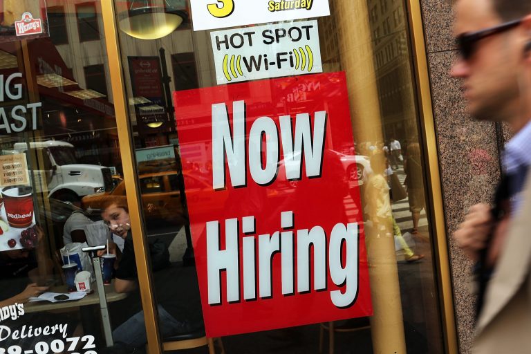 A 'now hiring' sign is viewed in the window of a fast food restaurant on August 7, 2012 in New York City. (Photo by Spencer Platt/Getty Images)
