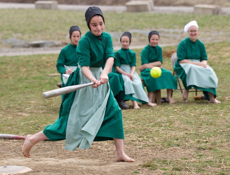 Amish girls play softball after class during an end of the school year celebration on Tuesday, April 9, 2013 in Bergholz, Ohio. The celebration was also part of a farewell picnic for four women and one man from this tight-knit group in rural eastern Ohio who will enter prison on Friday, April 12, joining nine already behind bars on hate crimes convictions for hair- and beard-cutting attacks against fellow Amish. (AP Photo/Scott R. Galvin)