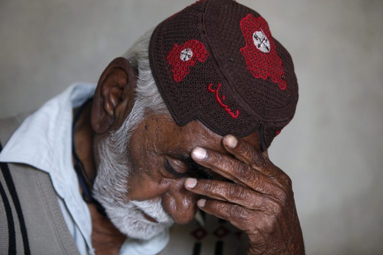 In this Wednesday, Feb. 26, 2014 photo, Pakistani Jamal Din, father of police officer Didar Ahmed, who was killed along with three other police officers in early February, reacts while talking about his son at his home in Karachi, Pakistan. The jacket that Karachi police officer Didar Ahmed was wearing when he was killed was given back to his family after his death. Bullet holes have pierced the sleeves and chest, marking where Ahmed was shot. In some areas the jacket is stained dark with dried blood. (AP Photo/Shakil Adil)