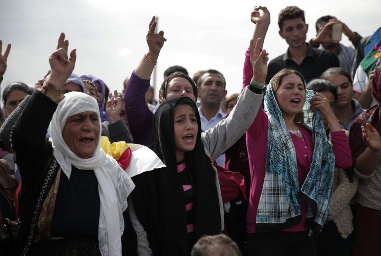 Mourners chant slogans during the funeral of four female Kurdish fighters, killed in the fighting with the militants of the Islamic State group in Kobani, Syria, at a cemetery in Suruc, on the Turkey-Syria border, Tuesday, Oct. 14, 2014. Kobani, also known as Ayn Arab, and its surrounding areas, has been under assault by extremists of the Islamic State group since mid-September and is being defended by Kurdish fighters. (AP Photo/Lefteris Pitarakis)