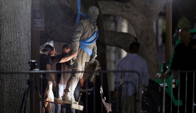A statue of Confederate Gen. Robert E. Lee is removed from the University of Texas campus, early Monday mornin, in Austin, Texas. University of Texas President Greg Fenves ordered the immediate removal of statues of Robert E. Lee and other prominent Confederate figures from a main area of campus, saying such monuments have become 