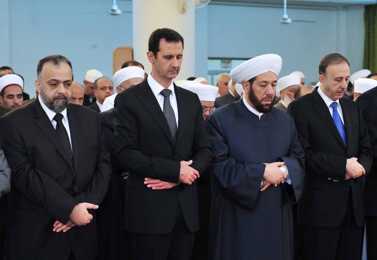 In this photo released by the Syrian official news agency SANA, Syrian President Bashar Assad, second left, prays during Eid al-Adha prayer at a mosque in Damascus, Syria, on Saturday Oct. 4, 2014. Assad has made a rare public appearance by attending prayers at a mosque in the capital, marking the beginning of the important Muslim holiday. (AP Photo/SANA)