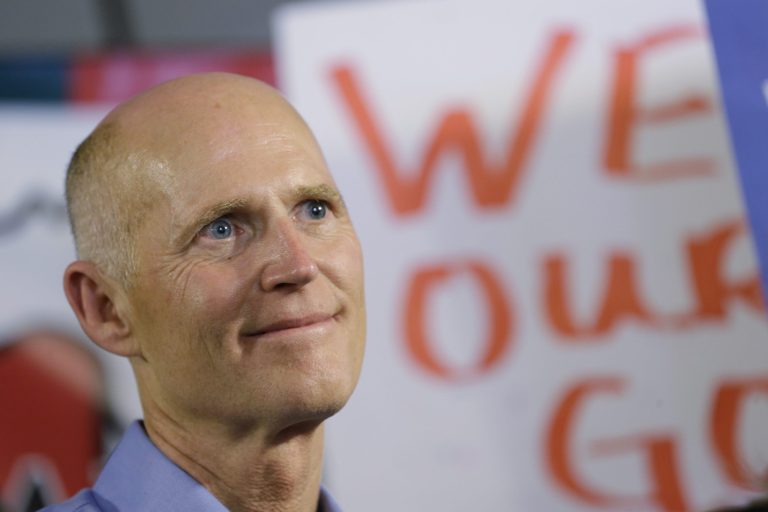 Florida Gov. Rick Scott looks on before addressing the crowd during a campaign stop at the Jacaranda Italian Restaurant and Pizzeria, Sunday, Oct. 26, 2014 in Plantation, Fla. (AP Photo/Wilfredo Lee)