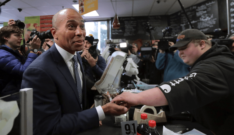 Democratic presidential candidate former Massachusetts Gov. Deval Patrick receives his change after paying for a food order while campaigning Thursday, Nov. 14, 2019, at The Bridge Cafe in Manchester, N.H. (AP Photo/Charles Krupa)