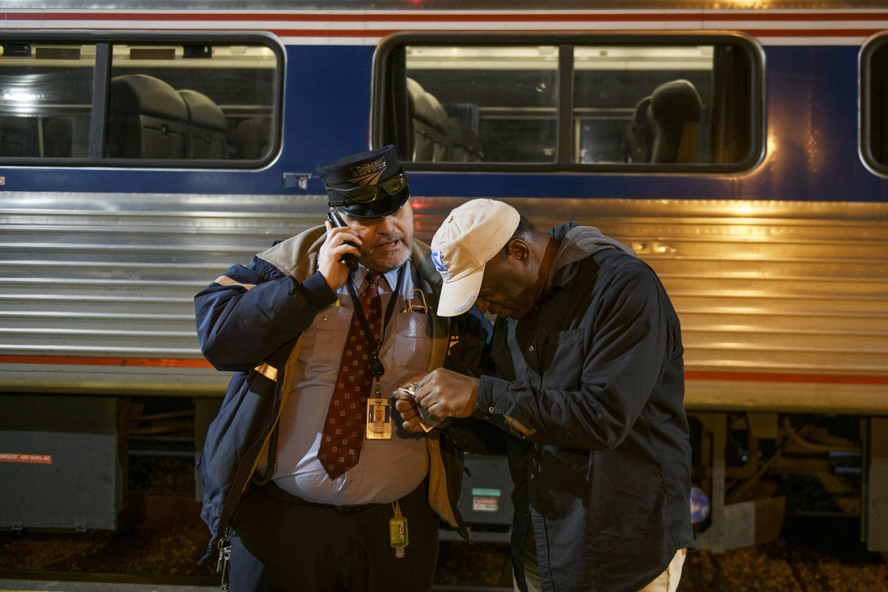 Capitol Limited train conductor Greg Gurganus assists a passenger with a ticket at Union Station in Pittsburgh.