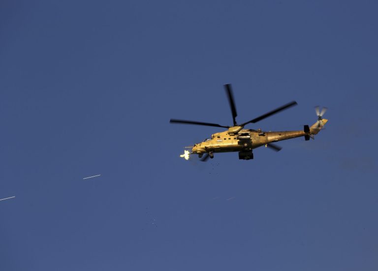 FILE - In this Thursday, March 26, 2015 file photo, an Iraqi military helicopter attacks Islamic State group positions during clashes in Tikrit, 130 kilometers (80 miles) north of Baghdad, Iraq. Iraqi troops started the final phase of an offensive to recapture Saddam Hussein's hometown of Tikrit on Thursday, a military official said, just hours after the United States launched airstrikes on the Islamic State held city. (AP Photo/Khalid Mohammed, File)