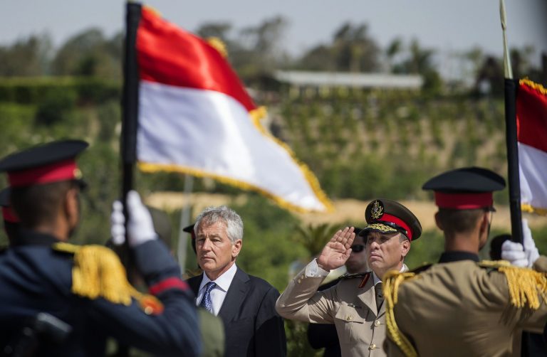 U.S. Secretary of Defense Chuck Hagel, center left, stands with an Egyptian army official before laying a wreath at the Tomb of the Unknown Soldier in Egypt's capital, Cairo on Wednesday, April 24, 2013. By including Cairo on his first Mideast tour as defense secretary, Chuck Hagel is highlighting the Obama administration's hope of preserving influence with the Egyptian military as the country struggles with its transition to democracy.(AP Photo/Jim Watson, Pool)