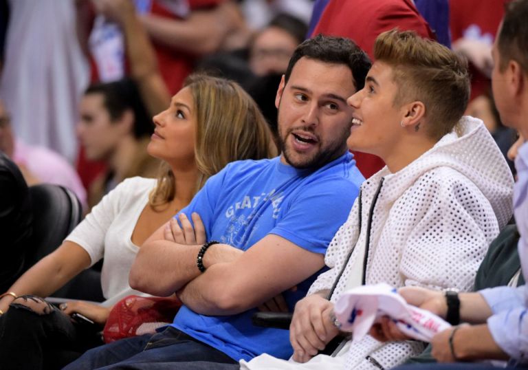 Justin Bieber watches the Los Angeles Clippers play the Oklahoma City Thunder along with his manager Scooter Braun and Braun's fiance Yael Cohen, Sunday, May 11, 2014, in Los Angeles. (AP Photo)Â 