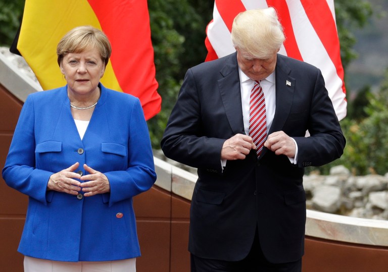 U.S. President Donald Trump, right, adjusts his jacket as he stands with German Chancellor Angela Merkel prior to a group photo during a G7 Summit in the Ancient Theatre of Taormina ( 3rd century BC) in the Sicilian citadel of Taormina, Italy, Friday, May 26, 2017. (AP Photo/Andrew Medichini)