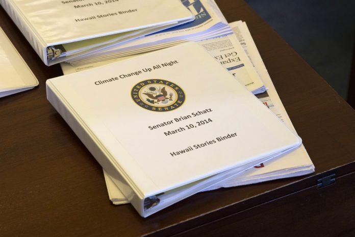 A binder containing climate change talking points and information for Sen. Brian Schatz, D-Hawaii, sits on a desk before a meeting of the Senate Climate Action Task Force prior to taking to the Senate Floor all night to urge action on climate change on Monday in Washington. (AP Photo/ Evan Vucci)