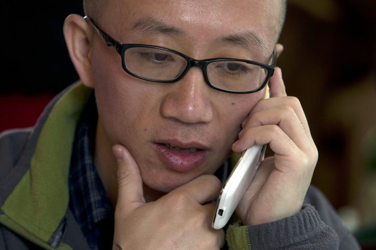 FOR USE WITH STORY CHINA SHIFTING TACTICS  BY DIDI TANG In this photo taken Wednesday, April 10, 2013, Chinese dissident Hu Jia talks on his phone during a meeting at a restaurant in Beijing, China. In prosecuting the countryâs political and social activists, an image-conscious Beijing is shifting its tactics. Rather than filing charges of inciting state subversion that amount to political prosecution and drawing international condemnations, Beijing is increasingly using public disorder charges to lock up those it considers as nuisances or threats to its rule. Hu describes this system as 