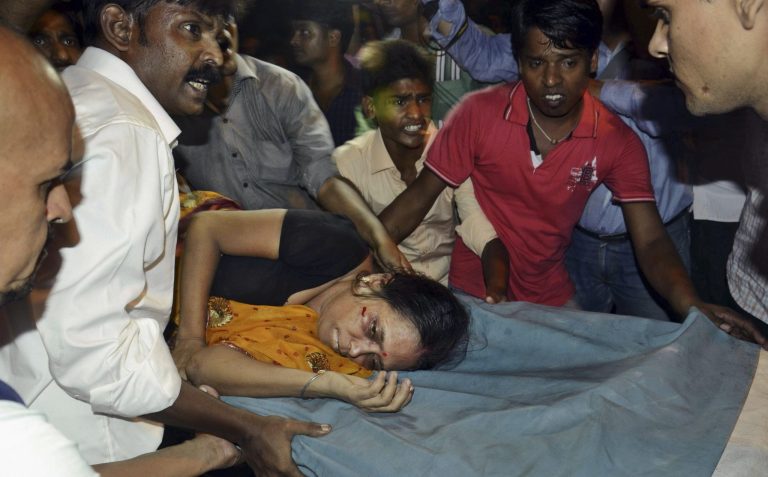An Injured woman is carried on a stretcher to a hospital for treatment in Patna, India, Friday, Oct. 3, 2014. Officials say at least 25 died in a stampede during the religious festival of Dussehra in eastern India. (AP Photo/Aftab Alam Siddiqui)