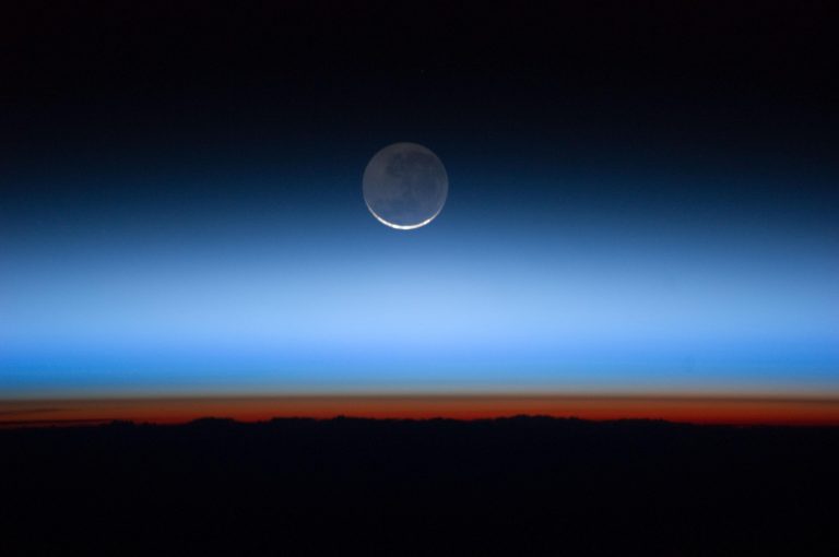   This undated image made available by NASA and photographed by the Expedition 28 crew aboard the International Space Station, shows the moon, at center with the limb of Earth near the bottom transitioning into the orange-colored troposphere, the lowest and most dense portion of the Earth's atmosphere. A team of former NASA executives are launching a private venture to send people to the moon for $1.5 billion. The newly formed business is offering countries a two-person trip to the moon, either for research or national prestige. The venture was announced Wednesday, Dec. 6, 2012. (AP Photo/NASA)  