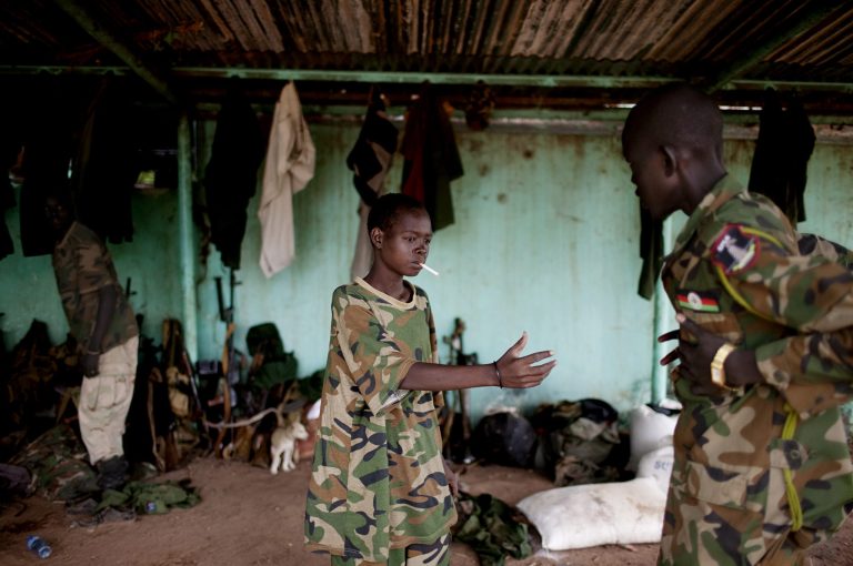 FILE - In this Friday, May 11, 2012 file photo, a young South Sudanese soldier who appeared to be drunk reaches for a lighter for his cigarette at the Sudan People's Liberation Army (SPLA) headquarters in Bentiu, Unity State, South Sudan. The U.N.'s top official for children and armed conflicts Leila Zerrougui said during a stop in Kenya on Thursday, Aug. 21, 2014 that the use of child soldiers and violence against children is commonplace in South Sudan's year of warfare. (AP Photo/Pete Muller, File)
