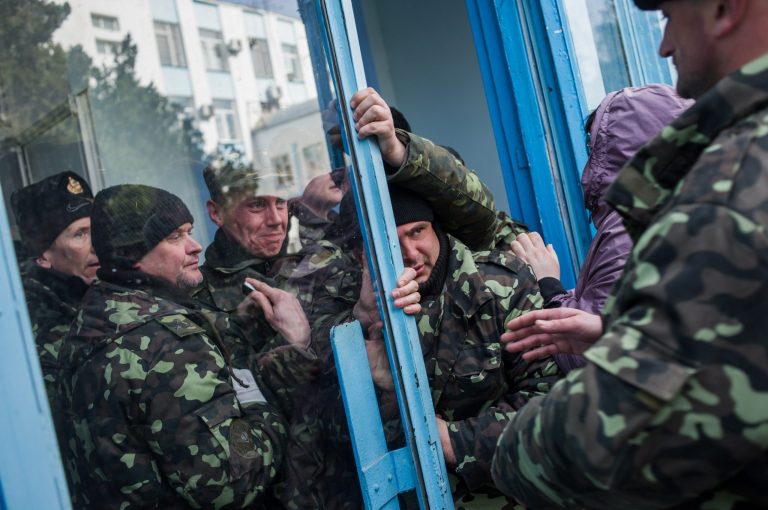 Pro-Russian self-defense force members get through an entrance to the Ukrainian Navy headquarters in Sevastopol, Crimea, Wednesday. (AP Photo/Andrew Lubimov)