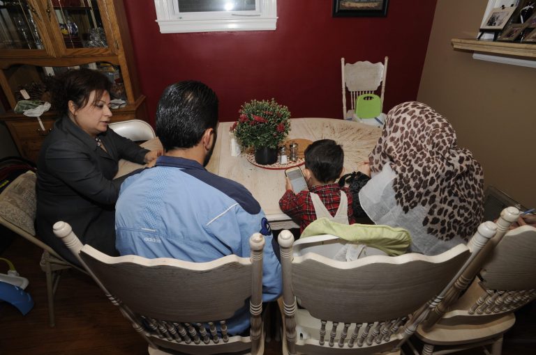 Jeralda Hattar, left, talks with Syrian refugees Mahmoud Karaz and his wife, Khairat, and son Ammar Karaz, in Dearborn, Mich. (AP Photo/Jose Juarez)