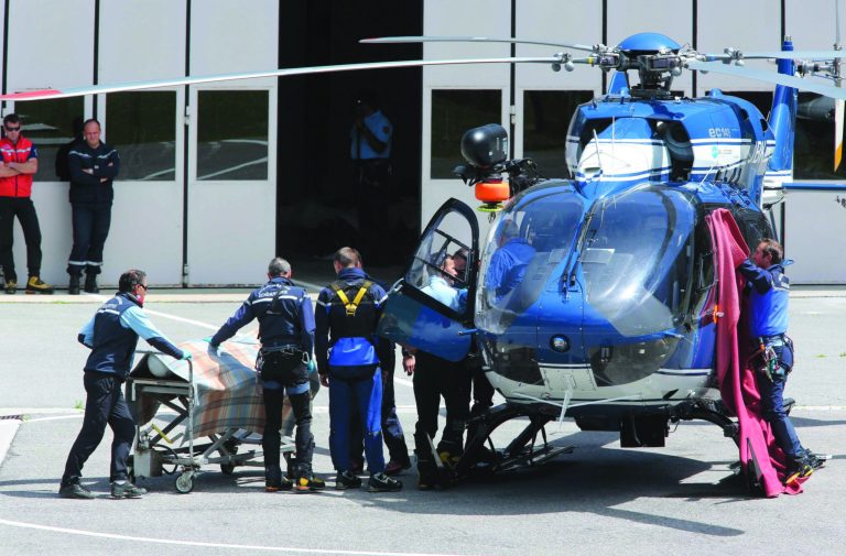Gendarmes use blankets to hide victims of an avalanche at Chamonix rescue base, French Alps, Thursday, July, 12, 2012. An avalanche in the French Alps swept six European climbers to their deaths on a slope leading to Mont Blanc, and left at least nine others injured and several climbers unaccounted for, authorities said. Two climbers were rescued and emergency crews are searching for the missing. A group of 28 climbers from Switzerland, Germany, Spain, France, Denmark and Serbia are believed to be in the expedition caught in the avalanche that was about 4,000 meters (13,1000 feet) high on the north face of Mont Maudit, part of the Mont Blanc range. (AP Photo)