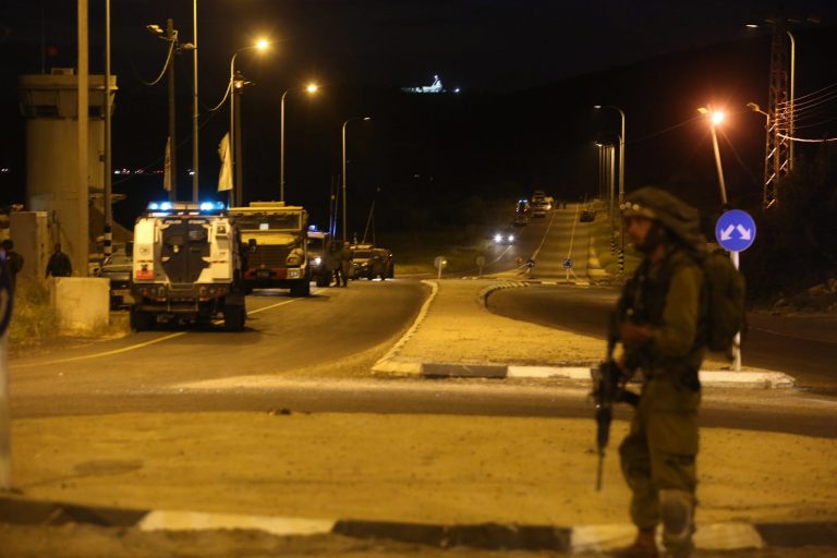 An Israeli soldier stands guard near the scene of a shooting near  the Tarqumiya checkpoint, near the West Bank city of Hebron, Monday, April 14, 2014. Police say assailants opened fire on an Israeli vehicle in the West Bank, killing one person and wounding two. (AP Photo/Gil Yohanan) ISRAEL OUT