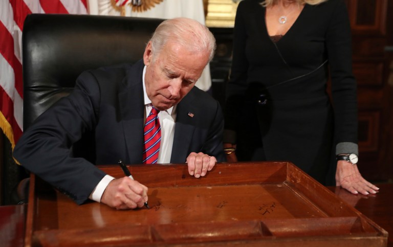 Vice President Joe Biden signs the drawer of the vice president's desk in the vice president's ceremonial office at the Eisenhower Executive Office Building on the White House complex, as his wife Jill Biden watches. (AP Photo/Manuel Balce Ceneta)