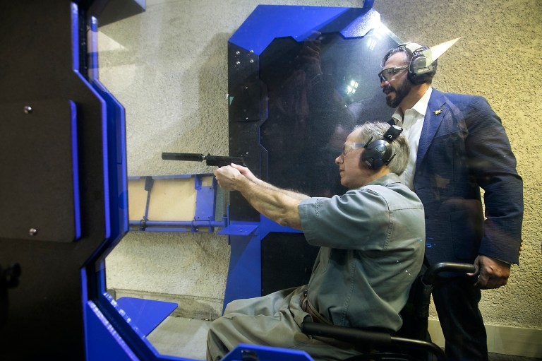 The governor was at the shooting range to sign a bill that lowers the cost of a license to carry a handgun. (Ralph Barrera/Austin American-Statesman via AP)